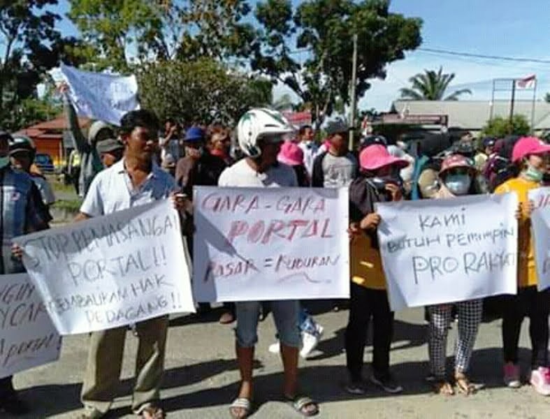 Pedagang menggelar aksi sembari membuat tulisan protes di karton